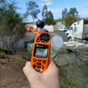 handheld weather meter in hand